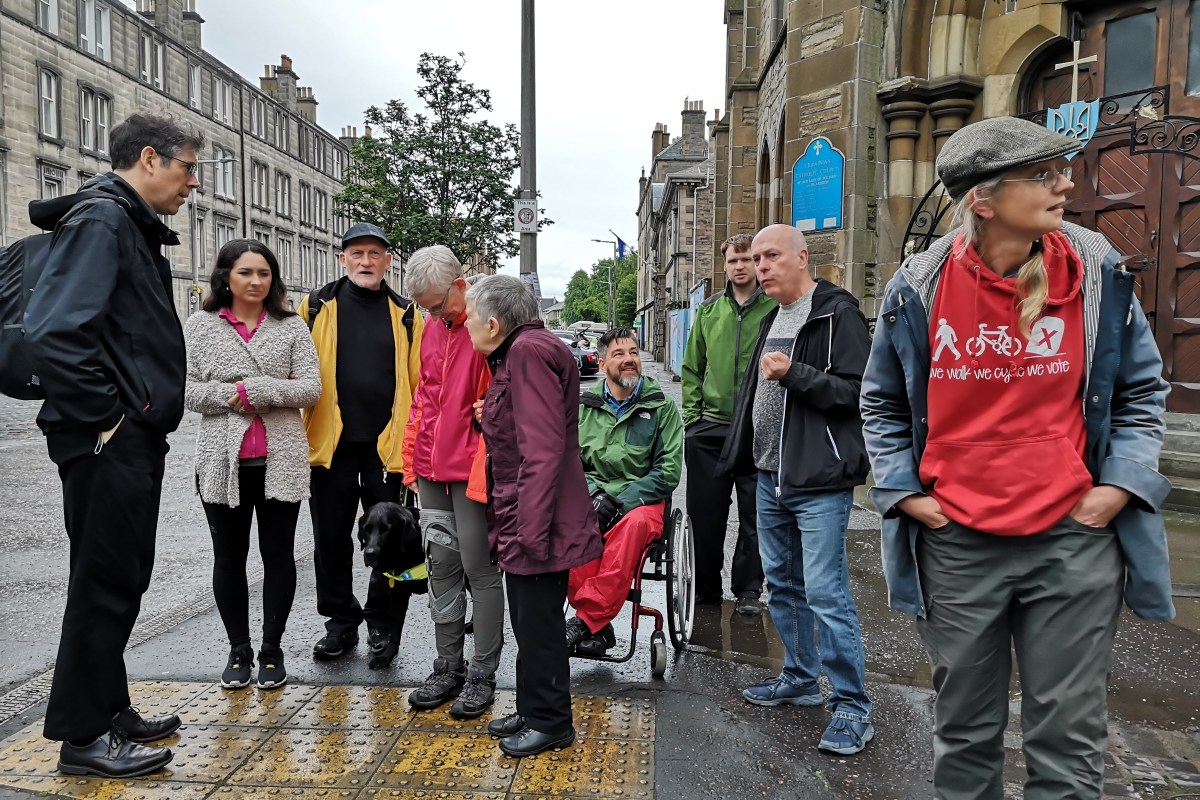 A group of people talking at a crossing